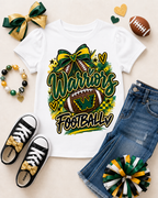 A white short-sleeve graphic T-shirt laid flat with a colorful 'Warriors Football' design featuring a football, bow, hearts, and checkered accents. The shirt is styled in a flat lay with blue jeans, black sneakers with gold bows, a green and gold ribbon, a beaded bracelet, a football, and heart-shaped decorations on a light beige background.